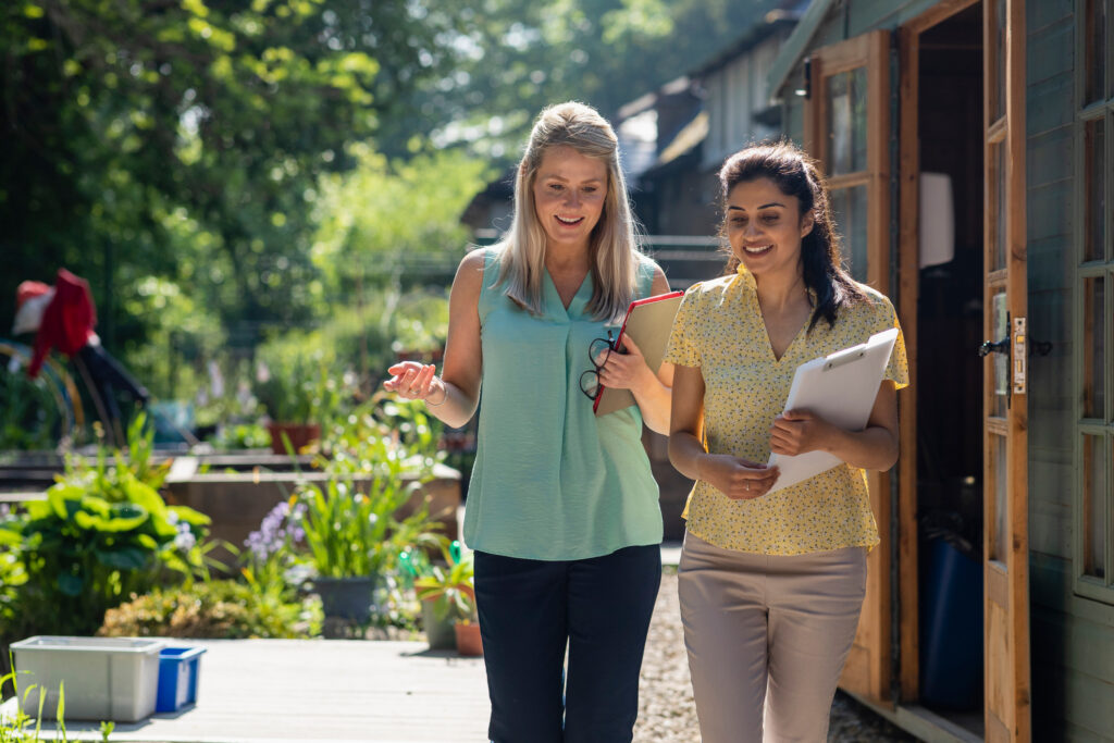  Two teachers walking and talking together outside. 