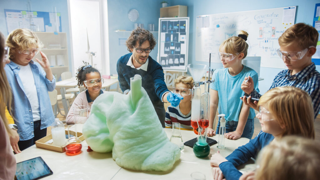 Children in science class with teacher conducting experiments.